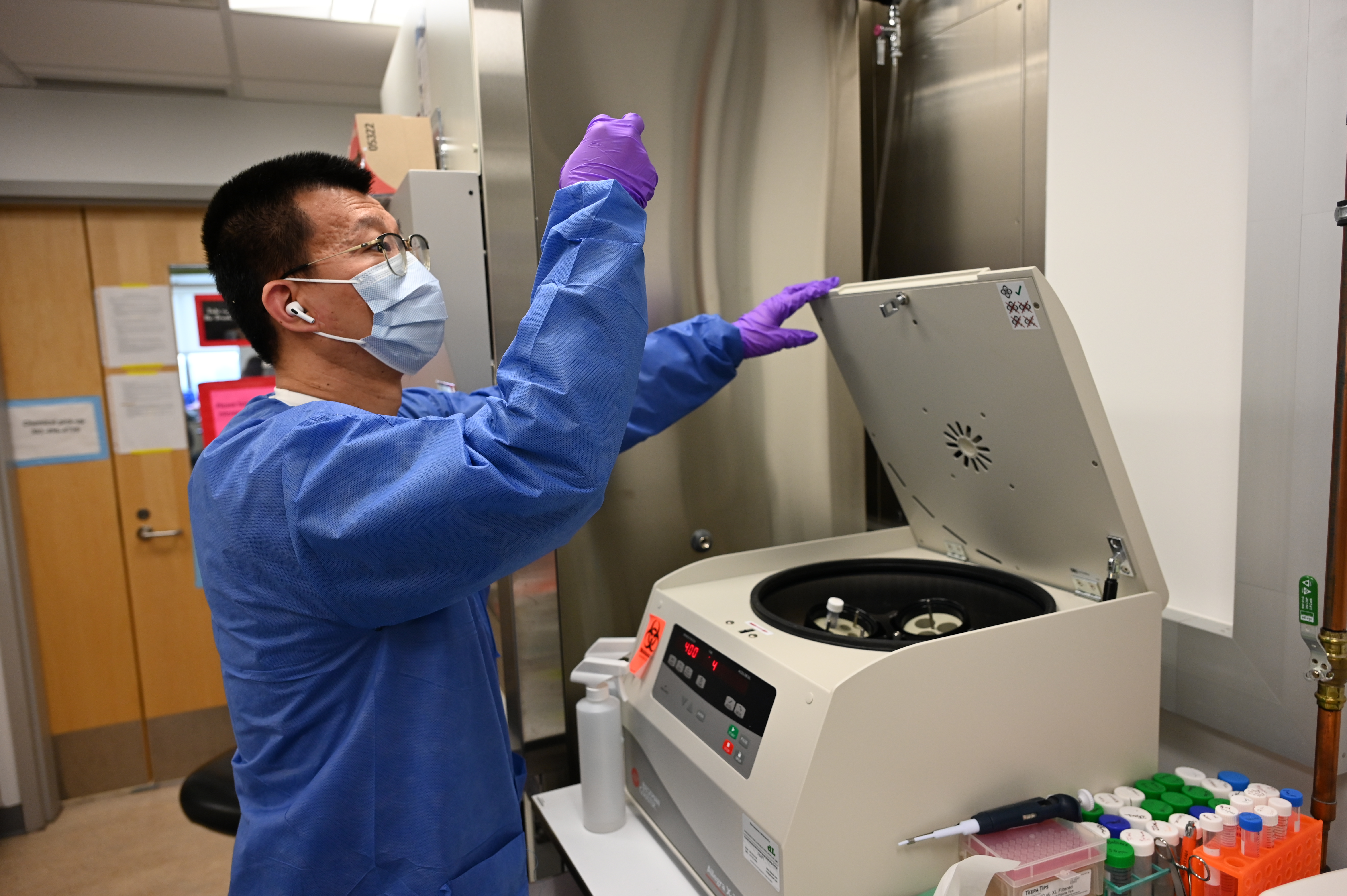 Researcher examing samples at a centrifuge