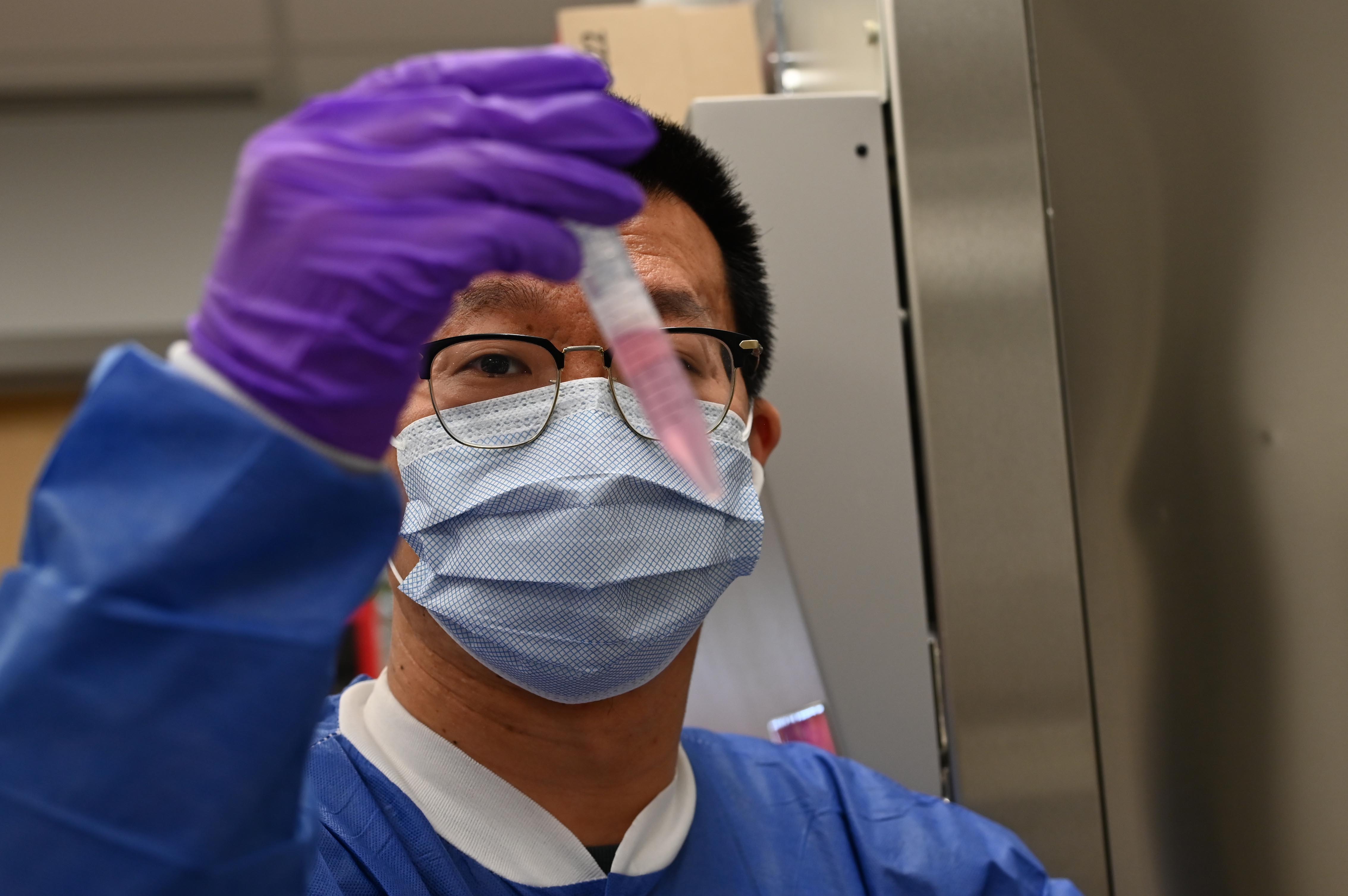 Researcher examining a vial