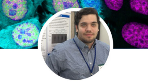 Male student standing in front of a scientific poster
