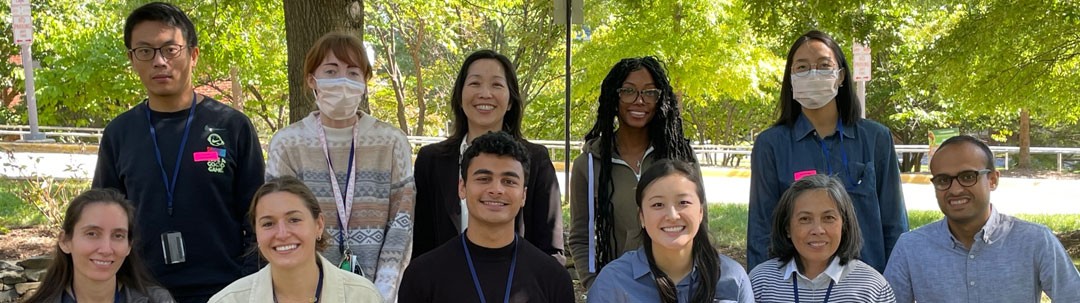 Staff of the Kong Lab, photographed outside in front of some trees.