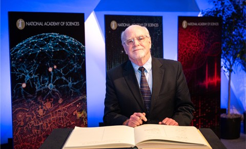 Photo of Dr. John O'Shea signing a book