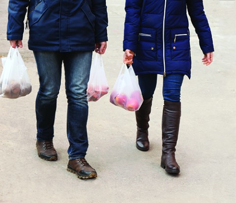 A couple wearing comfortable shoes, carrying groceries