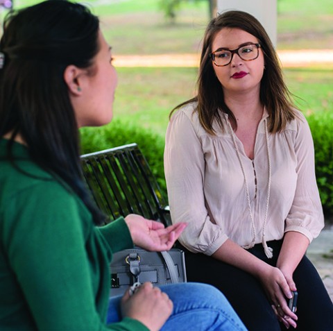 Two women sitting on a bench, having a discussion&nbsp;
