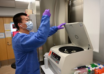 Researcher examing samples at a centrifuge