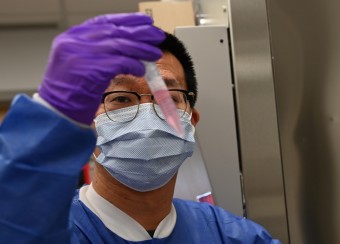 Researcher examining a vial
