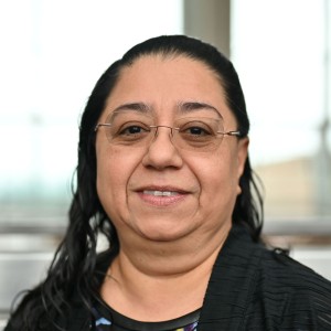 headshot of a woman long dark hair, tied back.