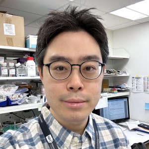 Headshot of a man wearing glasses in a lab.