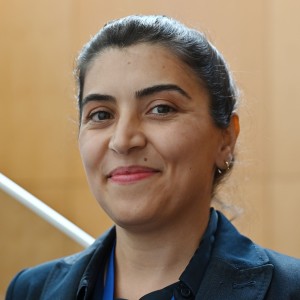 Headshot of a woman with tied back hair.