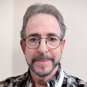Headshot of a man with a beard, smiling.