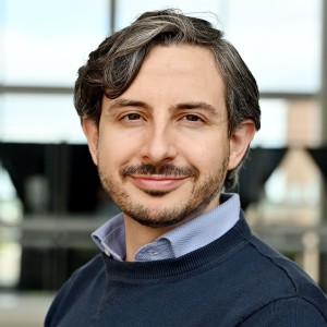 Headshot of a man outside in casual attire.