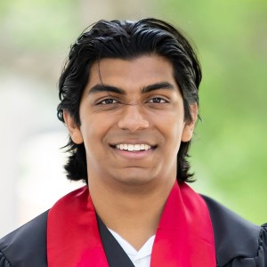 Headshot of a young man wearing college gowns.