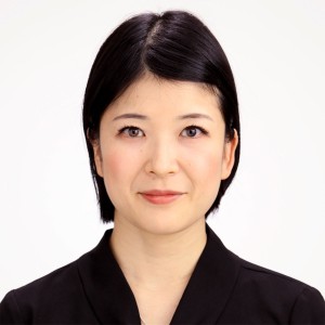 Headshot of an asian woman with short hair, in professional attire.
