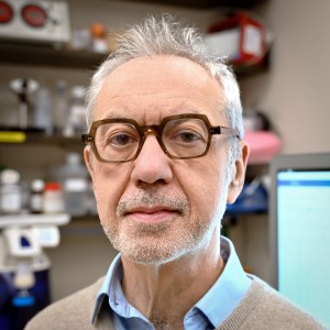 Headshot of a man wearing glasses, in a laboratory.