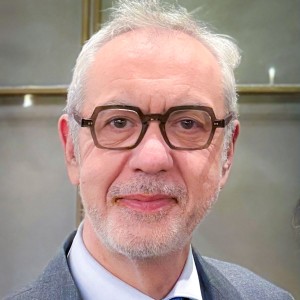 Headshot of a man wearing glasses, in a laboratory.