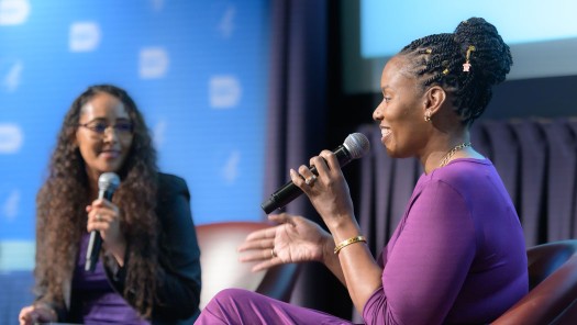 Two women on a stage conversing