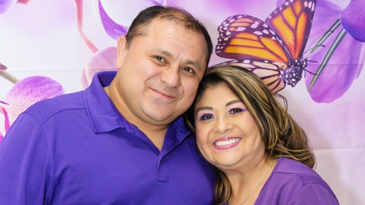 A man and woman standing close together smiling.