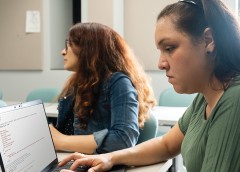 Photo of a person reading text on a laptop