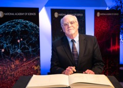 Photo of Dr. John O'Shea signing a book